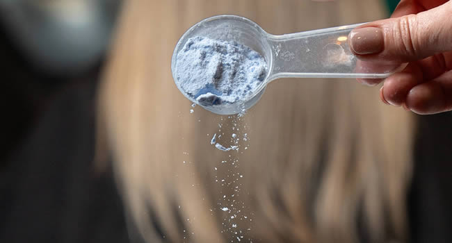 Friseur bereitet Farbe für eine Haarfärbung vor.